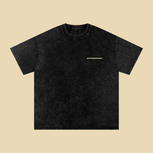 Front of the washed black Somehow, Still Room tee, with a small Supperstition wordmark on the left chest.